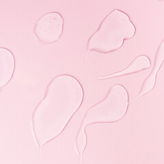 Samples of a transparent gel on a pink background. Texture of liquid cosmetic gel.