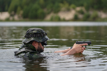 A marine aims a pistol in the water.