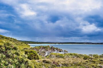 Unspoiled coastal scenery in Two Peoples Bay Nature Reserve, close to Albany, Western Australia. In the distance the long beach along the bay. Dark clouds.
