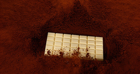 White Chocolate Tablet falling on Black Chocolate Powder