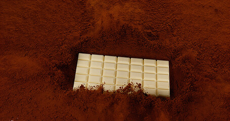 White Chocolate Tablet falling on Black Chocolate Powder
