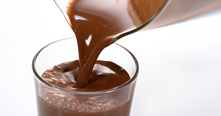 Chocolate Pouring into a Glass against White Background
