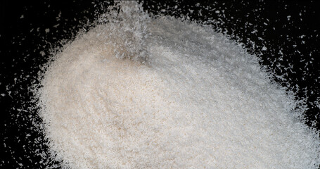 Coconut, cocos nucifera, Powder falling against Black Background
