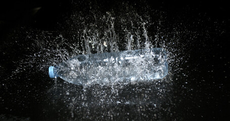 Bottle of Water falling on Water against Black Background