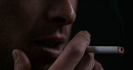 Man smoking a Cigarette against Black Background