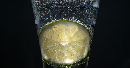 Slice of Green Lemon, citrus aurantifolia, in a Glass