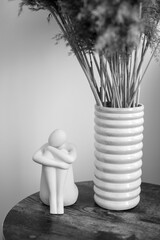human figurine and vase as an interior element in black and white