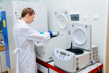 Scientist puts samples into centrifuge device