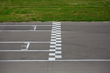 Finish line at the go-kart race track, side view. Asphalt track with markings for the correct start...