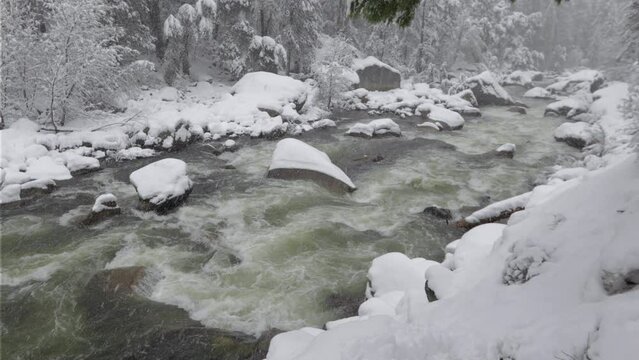 Footage - Running river with snow covered lands in Yosemite National Park