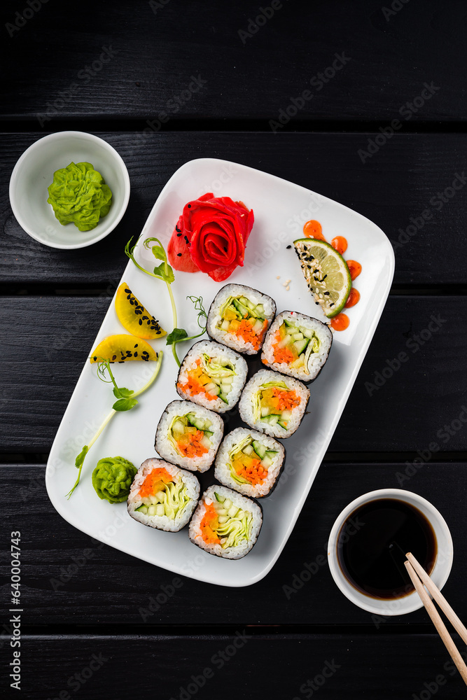 Wall mural sushi rolls with carrot, cabbage, cucumber, sweet pepper, wasabi, ginger and soy sauce.