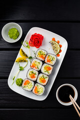 Sushi rolls with carrot, cabbage, cucumber, sweet pepper, wasabi, ginger and soy sauce.