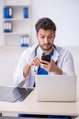 Fototapeta premium Young male doctor in telemedicine concept