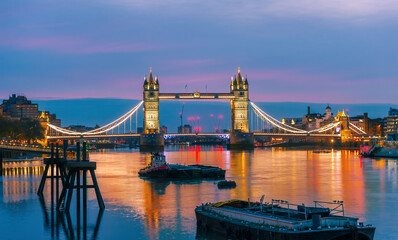 Panorama of the famous River Thames and the historical Tower Bridge illuminated at night in London Town, United Kingdom