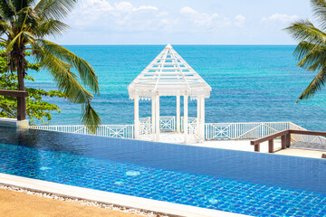 White gazebo on the blue sea with a swimming pool in the foreground. Rest and relaxation on the sea...