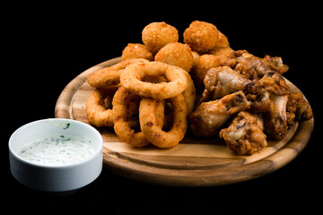 Snack crispy squid rings breaded (caramari), breaded mozzarella cheese balls, chicken legs and sauce.