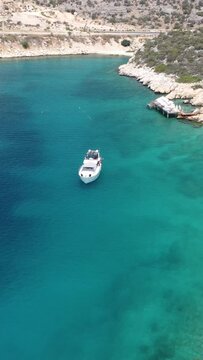 Drone shot of a white yact sailing off the coast of Turkey.