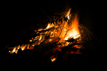 Big beautiful bonfire on black background. Real fire flames. Burning. Ignited. Night campfire. Orange color. Nature landscape. Outdoors recreation. Autumn garden cleaning. Hot. Close-up side view