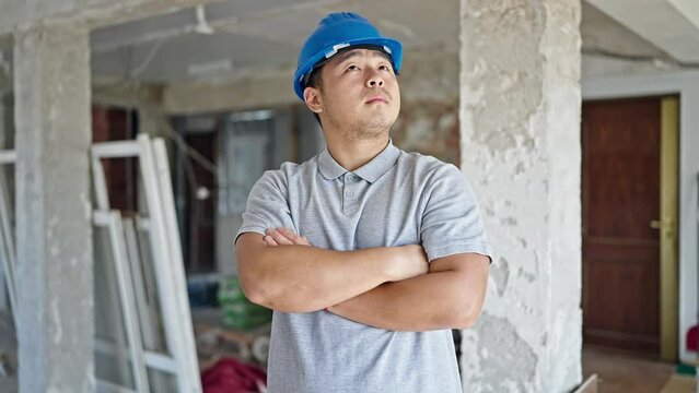  architect standing with arms crossed gesture looking around at construction site