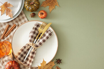 Creating a memorable Thanksgiving table. Top view of plate, cutlery, tablecloth, cinnamon sticks, colorful pumpkins, fallen leaves, cup on pastel green background with promotional slot