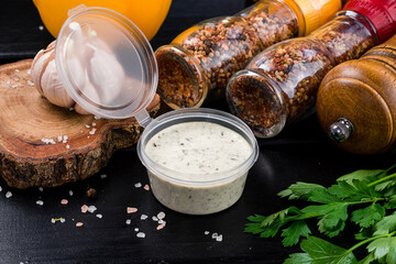 White sauce in a small bowl with spices and greens.