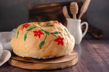 Loaf of bread hand painted with edible paints on a wooden board
