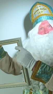saint nicholas draws in an empty frame with he has a white fluffy beard a suit blue with gold santa claus Christmas
