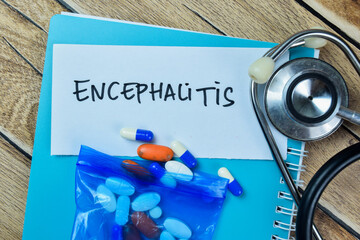 Concept of Encephalitis write on sticky notes with stethoscope isolated on Wooden Table.