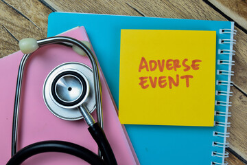 Concept of Adverse Event write on sticky notes with stethoscope isolated on Wooden Table.