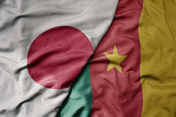 big waving national colorful flag of japan and national flag of cameroon .