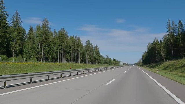 The car drives along the road on a summer day. Highways, roadside and road line markings.