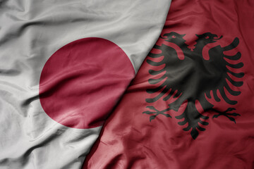 big waving national colorful flag of japan and national flag of albania .