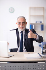 Old male employee working in the office