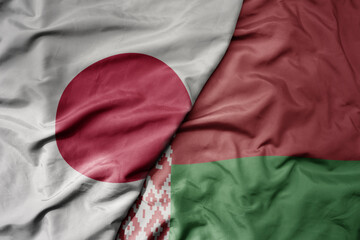 big waving national colorful flag of japan and national flag of belarus .