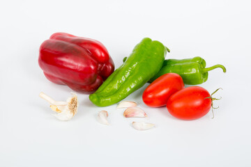 Still life on white background of vegetables, onions, peppers, garlics