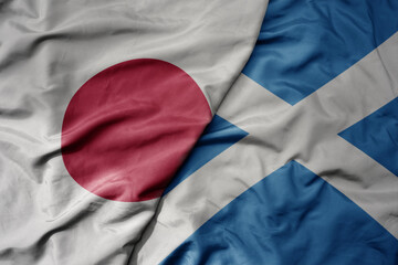 big waving national colorful flag of japan and national flag of scotland .