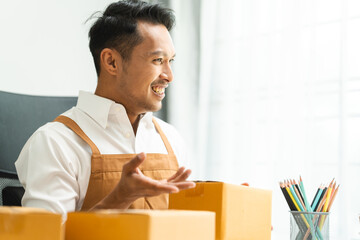 Startup SME small business entrepreneur of freelance Asian Indian man wearing apron prepare parcel delivery SME supply chain, procurement, package box to delivery.