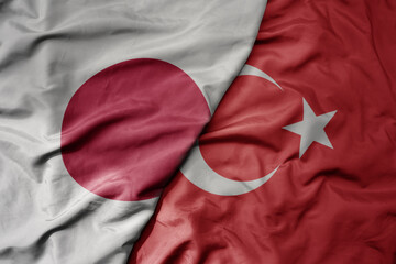 big waving national colorful flag of japan and national flag of turkey .