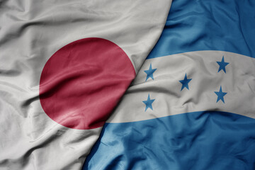 big waving national colorful flag of japan and national flag of honduras .