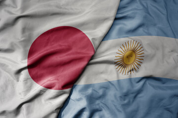 big waving national colorful flag of japan and national flag of argentina .