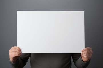 Man holding sheet of paper on grey background closeup