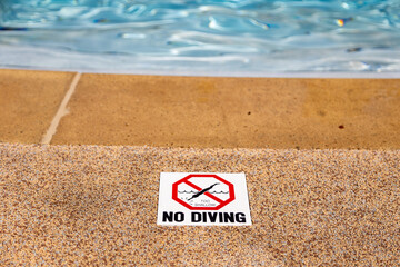 Edge of swimming pool with no diving warning sign