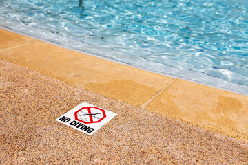 Swimming pool edge with warning sign and depth marker