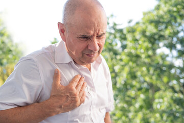 senior, mature man 60-65 years old holds to heart, sudden chest pain, close up male face with...