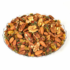 mixed dried nuts, almonds walnuts raisins and other nuts in glass bowl