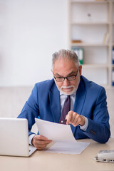 Old male employee working in the office