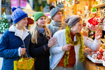 Happy family purchasing decorations at christmas fair shop.