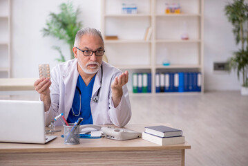 Old male doctor working in the clinic