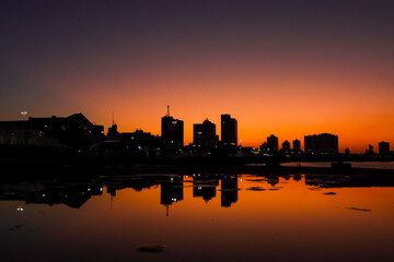 Fototapeta premium Campos dos Goytacazes, RJ, Brazil, 08/19/2023 - Woman and child with a bike in silhouette at sunset