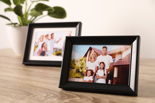 Frames with family photos on wooden table